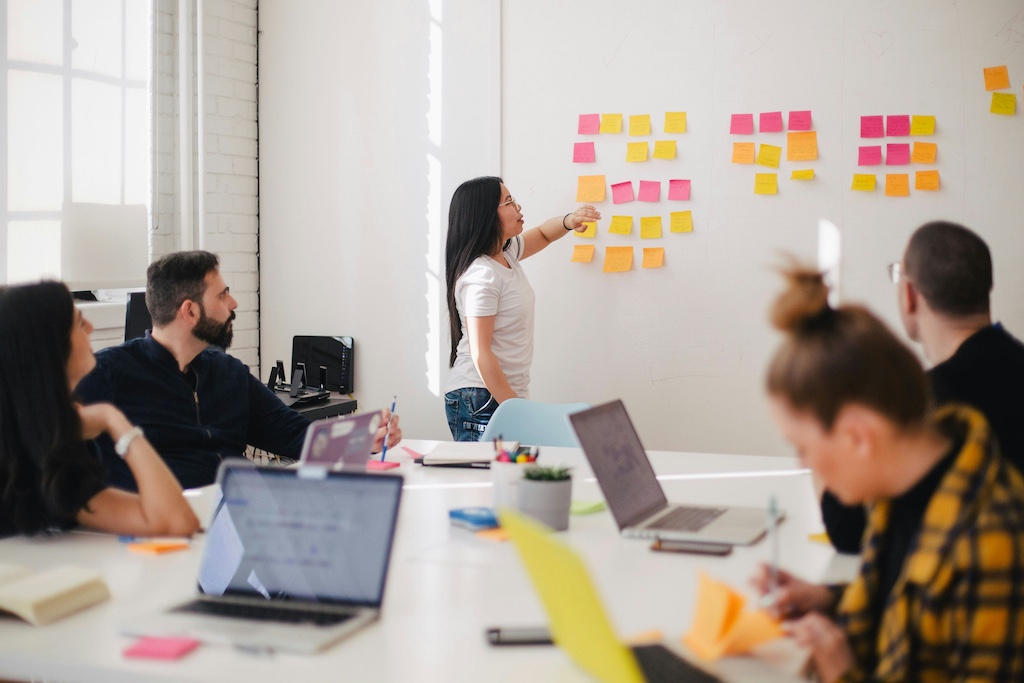 Woman placing sticky notes during a UX workshop